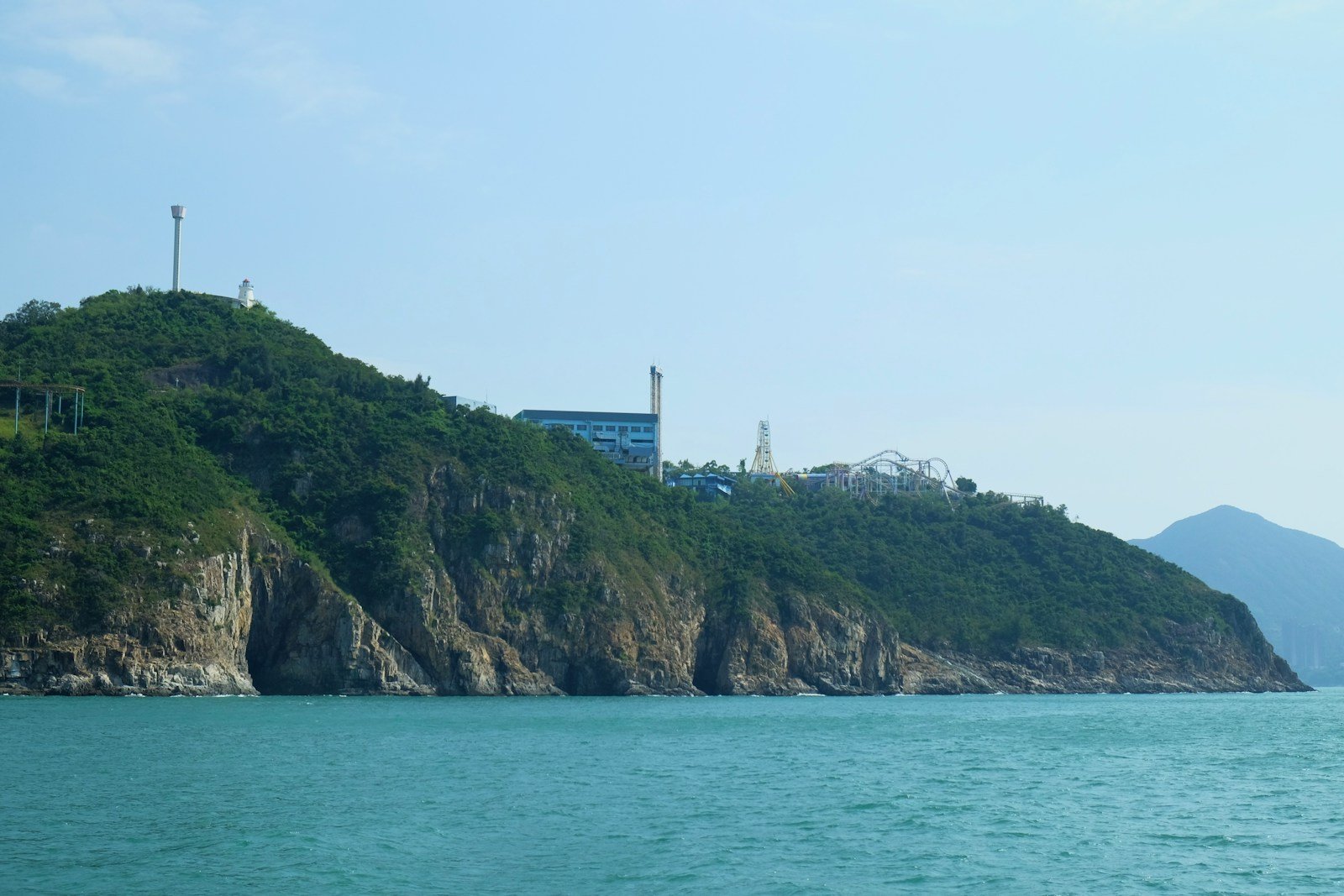 a large body of water sitting next to a lush green hillside