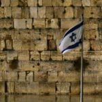 a flag is flying in front of a wall of bricks