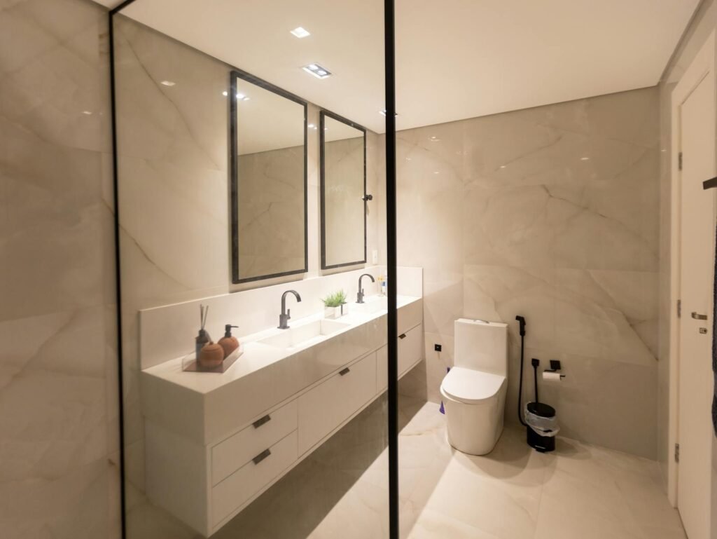 A stylish, minimalist bathroom with dual sinks, mirrors, and elegant decor in a modern setting.